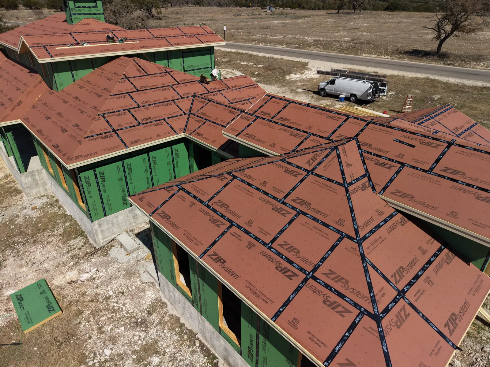 Aerial view of a custom home at dry-in stage with roof underlayment installed