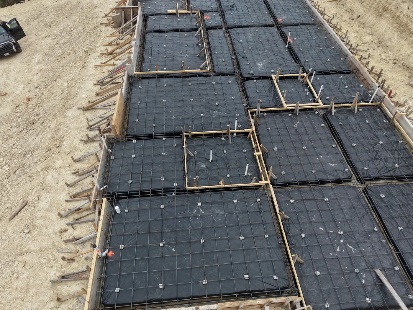 Engineered slab formwork with rebar and moisture barrier ready for a foundation pour