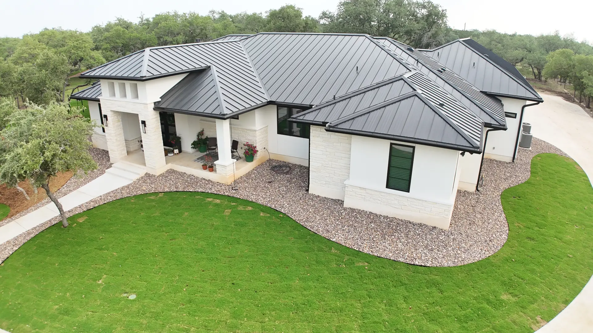 Aerial view of a completed Jay Rod's custom home with a standing-seam metal roof in the Texas Hill Country