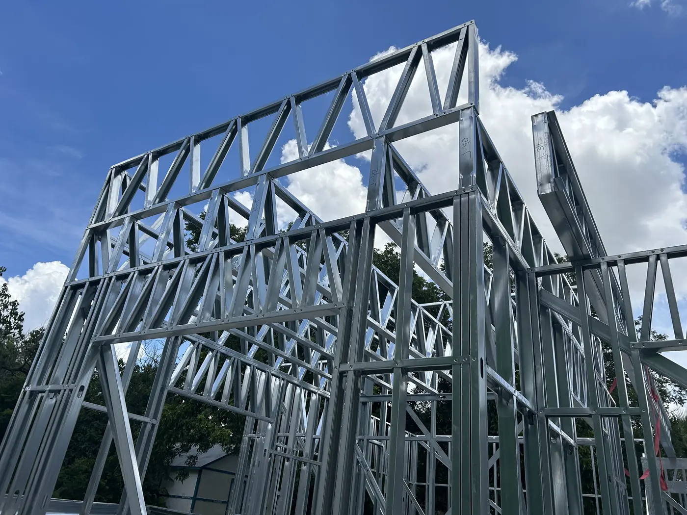 Steel truss framing of a new structure against a blue Texas sky